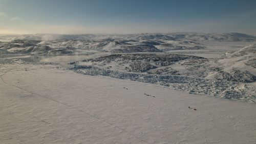 Free A breathtaking aerial shot of a vast snow-covered landscape with rugged hills in a serene Arctic region. Stock Photo