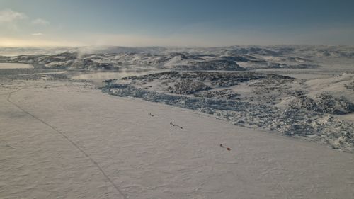 Free Stunning aerial shot of a snow-covered Arctic landscape with rugged mountains and icy terrain. Stock Photo
