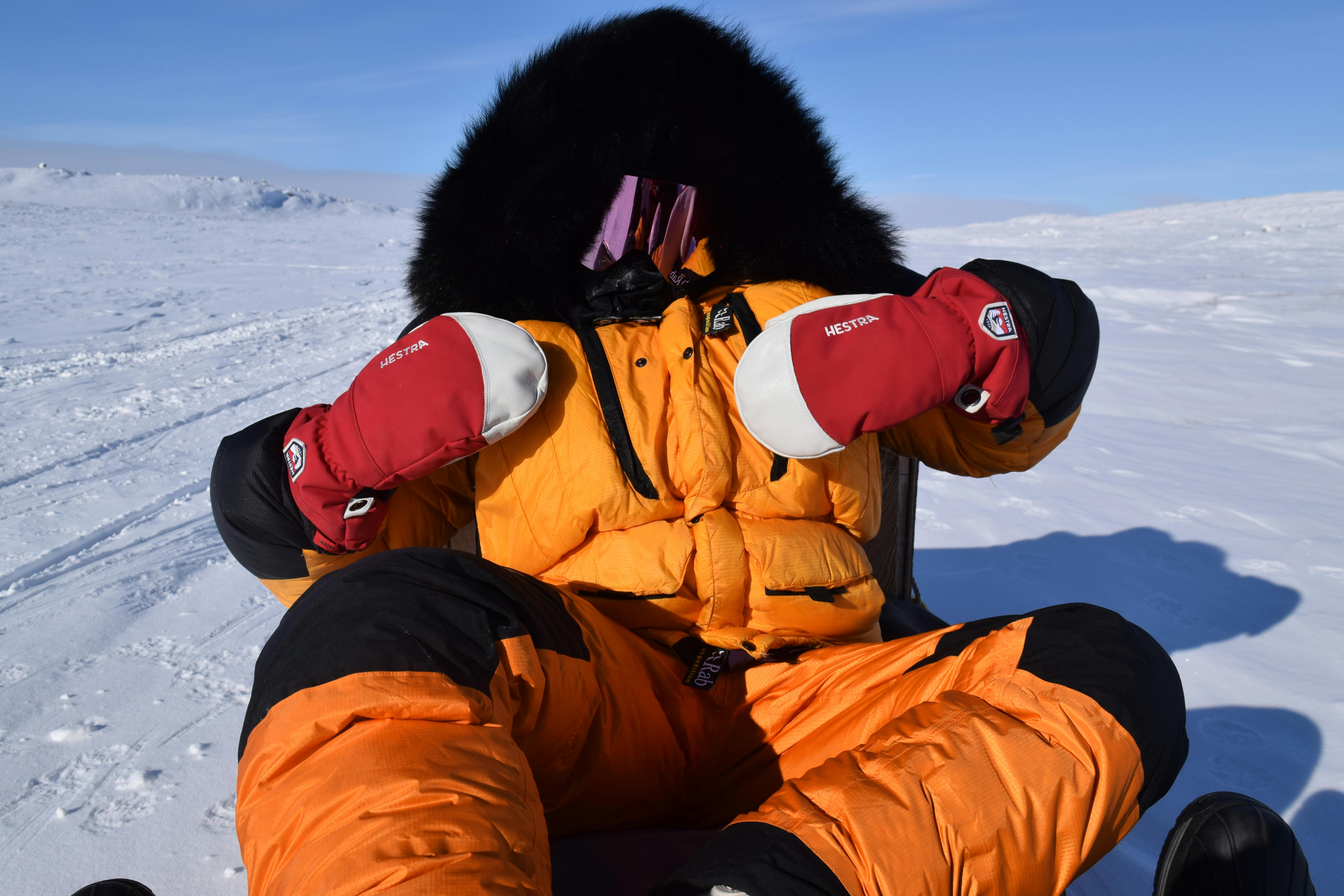 Prescription Goggle Inserts - Person in bright winter gear enjoying the snow, framed by a vast snowy landscape under clear skies.