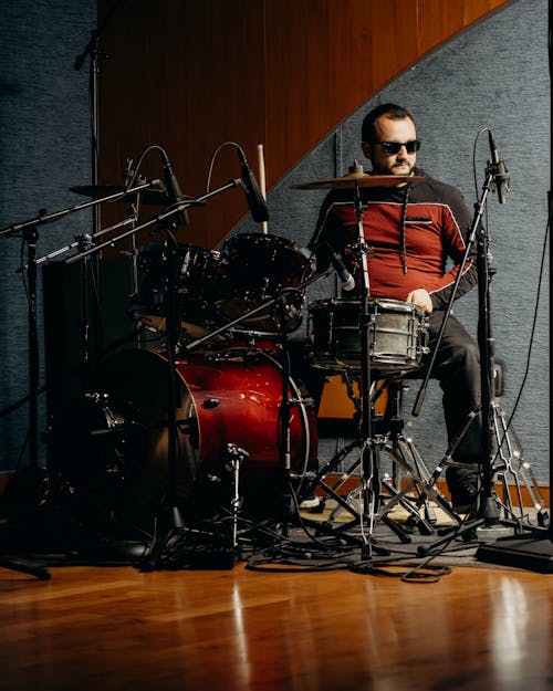 Free Man in Red and Black Jacket Playing the Drums Stock Photo