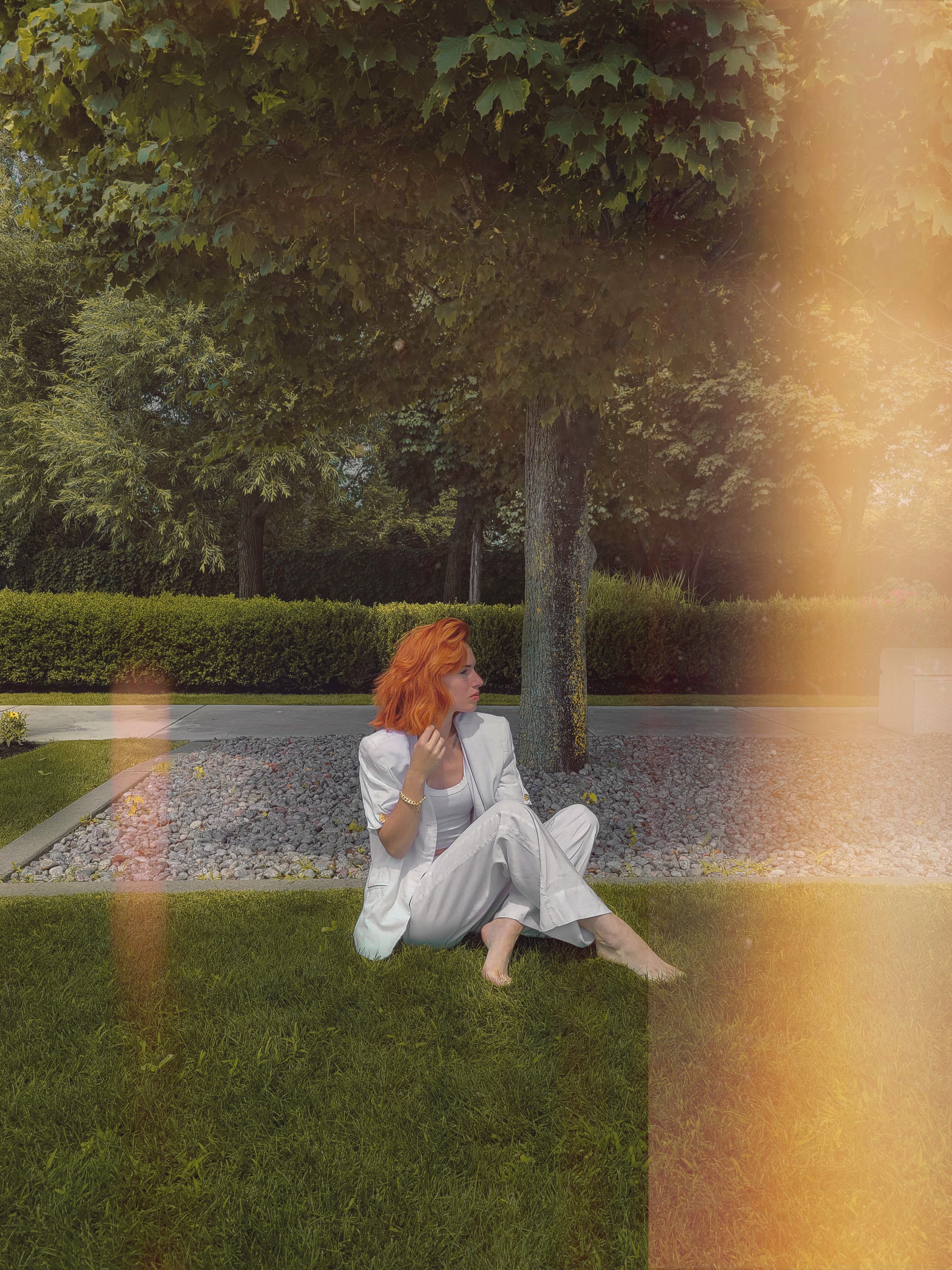 Woman in White Suit Sitting on Grass · Free Stock Photo