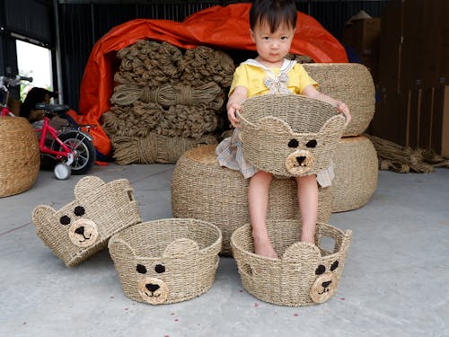 Free Girl in Red Shirt Sitting on Brown Wicker Basket With Brown Bear Plush Toy Stock Photo