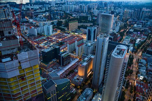 Free Dramatic aerial shot of bustling city streets and skyscrapers at dusk in Singapore. Stock Photo