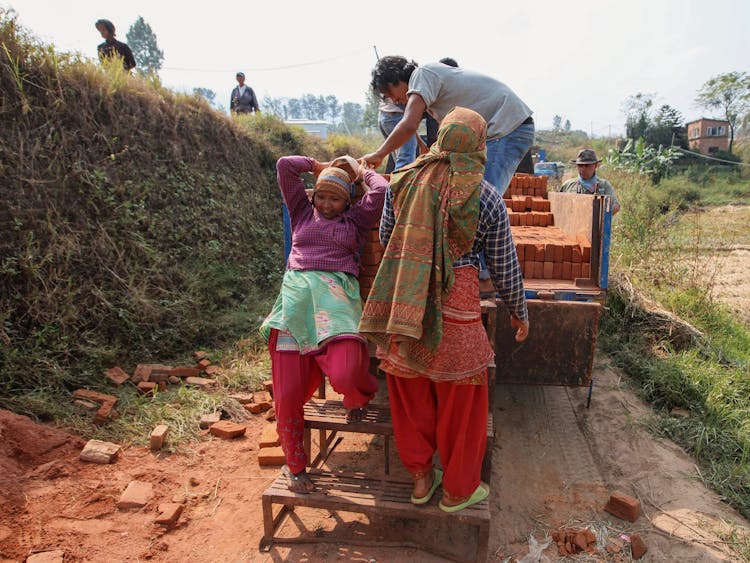 Workers Loading Bricks On A Truck