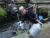 Man in Black Jacket Pouring Water on Gray Concrete Wall