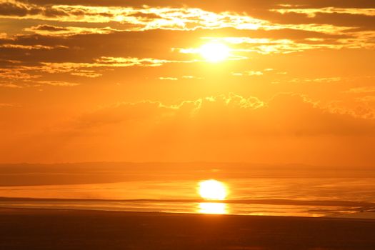 Stunning golden sunset over a serene ocean in Bhalgaon, India, reflecting warm hues.