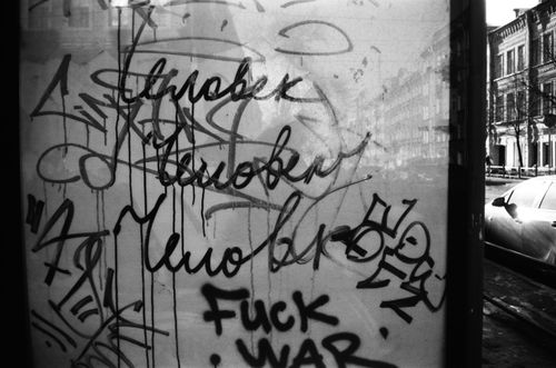 Free Black and white image of graffiti on a glass wall, showcasing urban street art. Stock Photo