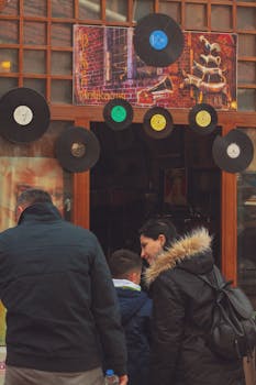 A family explores a retro music shop entrance decorated with vinyl records.