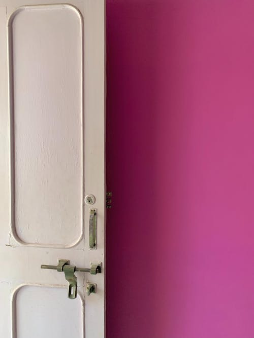 White Wooden Door With Silver Door Lever Near Pink Wall