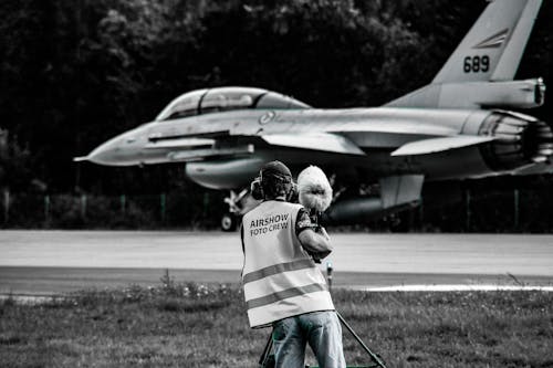 A Person in Reflective Vest Taking Photos of the the Aircraft