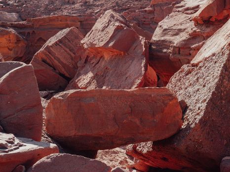Explore the rugged beauty of sandstone boulders in a vast desert landscape, showcasing nature's raw textures.