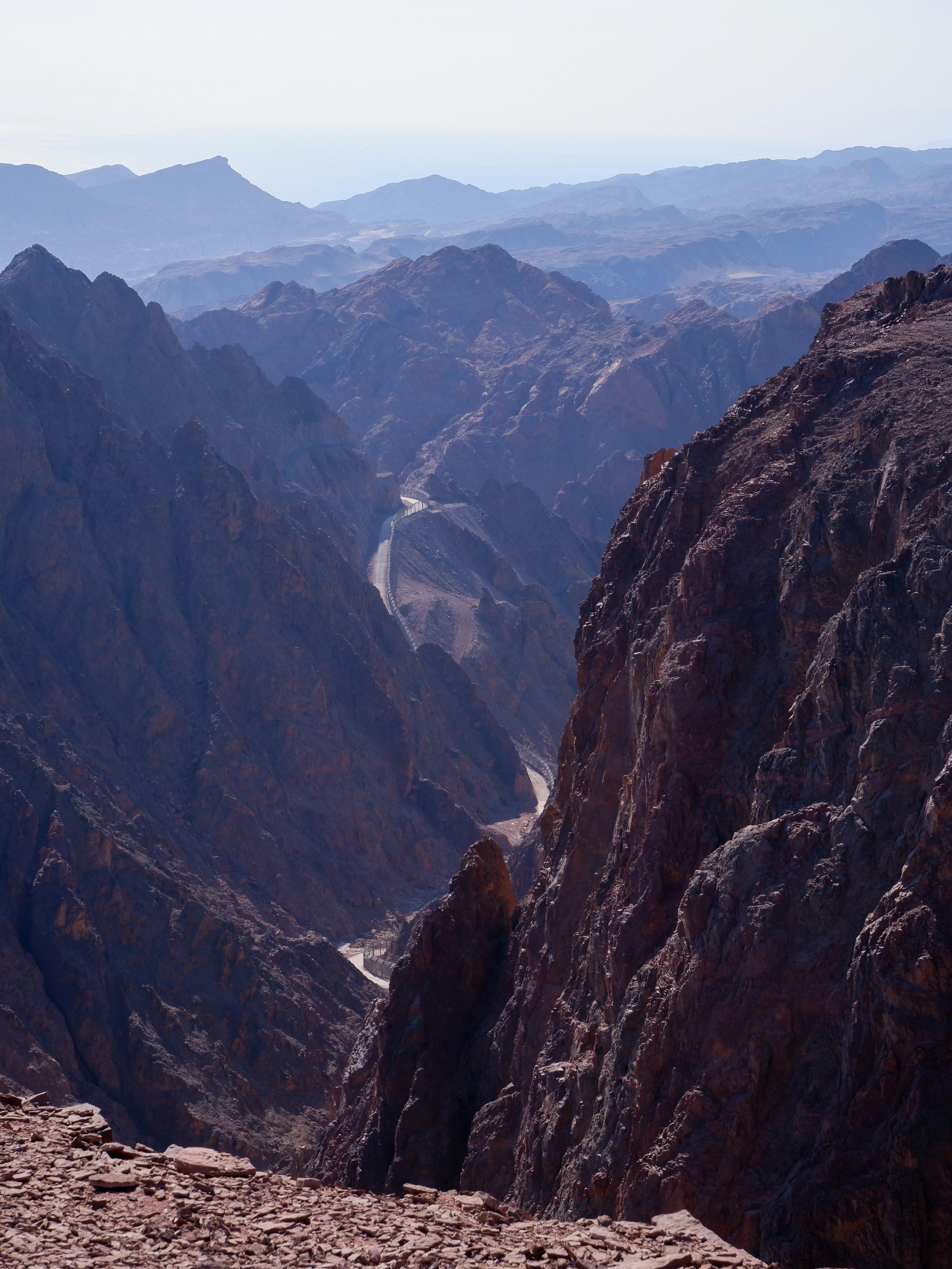 A breathtaking view of a rugged, dry mountain canyon under a clear sky.