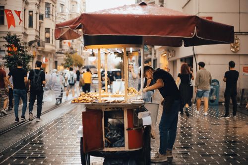 Free A bustling scene on Istiklal Avenue in Istanbul featuring a vibrant street food vendor cart. Stock Photo