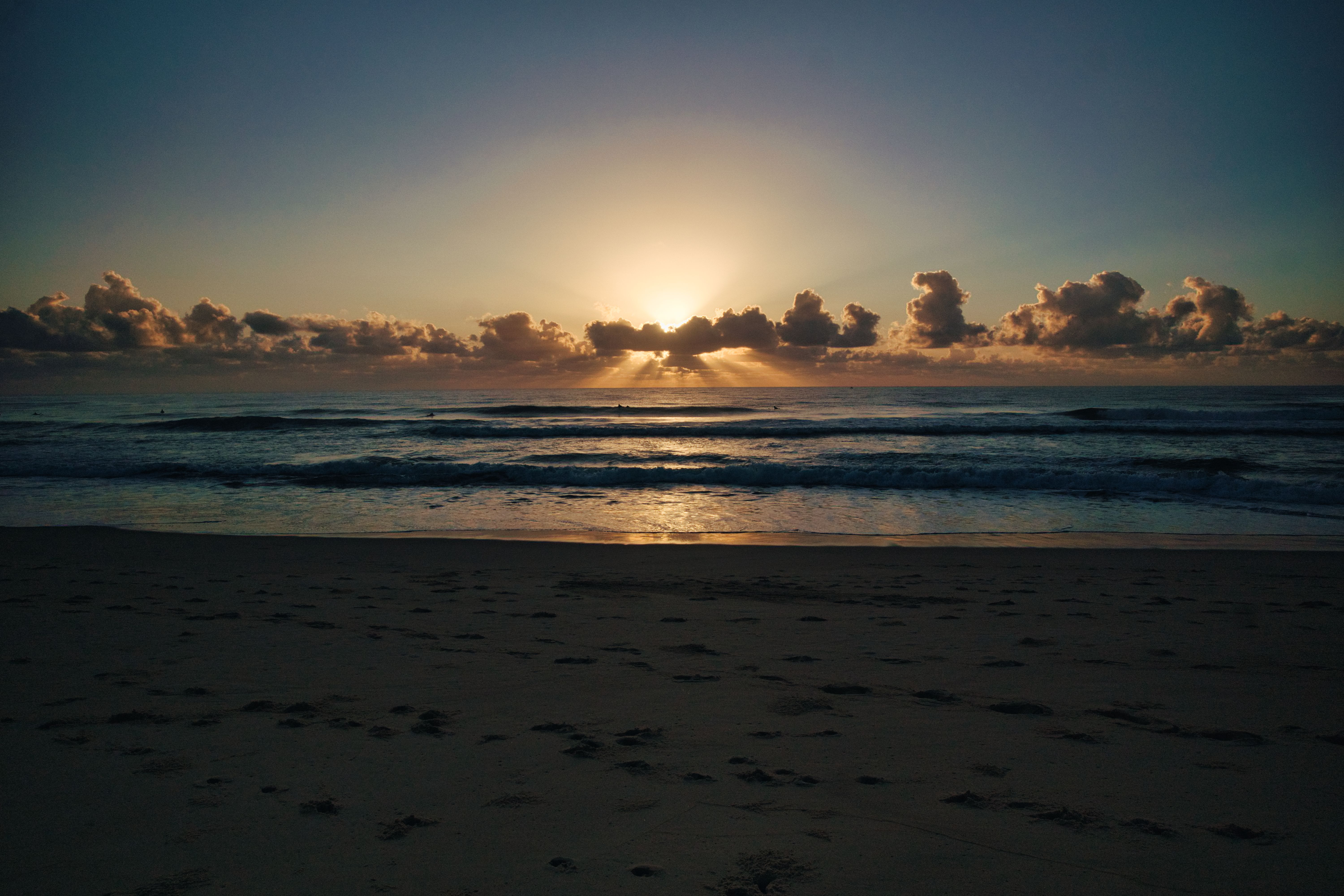 Sunrise over a tranquil Australian beach, footprints in the sand