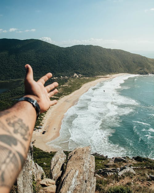 A Person on a Coastal Cliff  of Lagoinha Do Leste Beach in Santa Catalina, Brazil