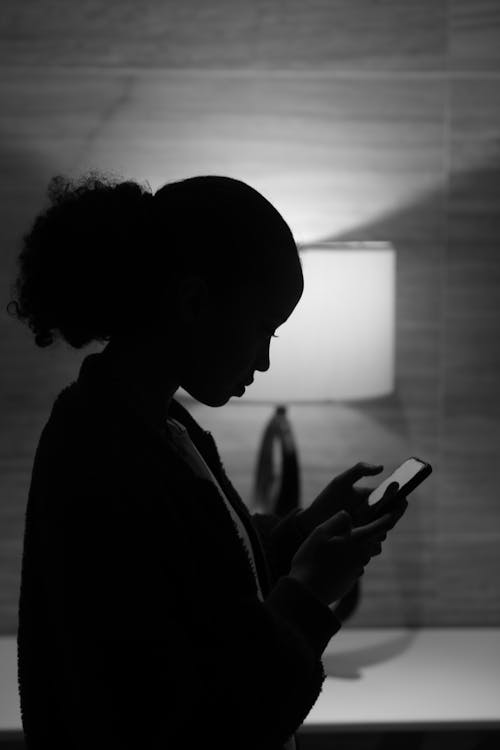 Grayscale Photo of a Woman Using Cellphone