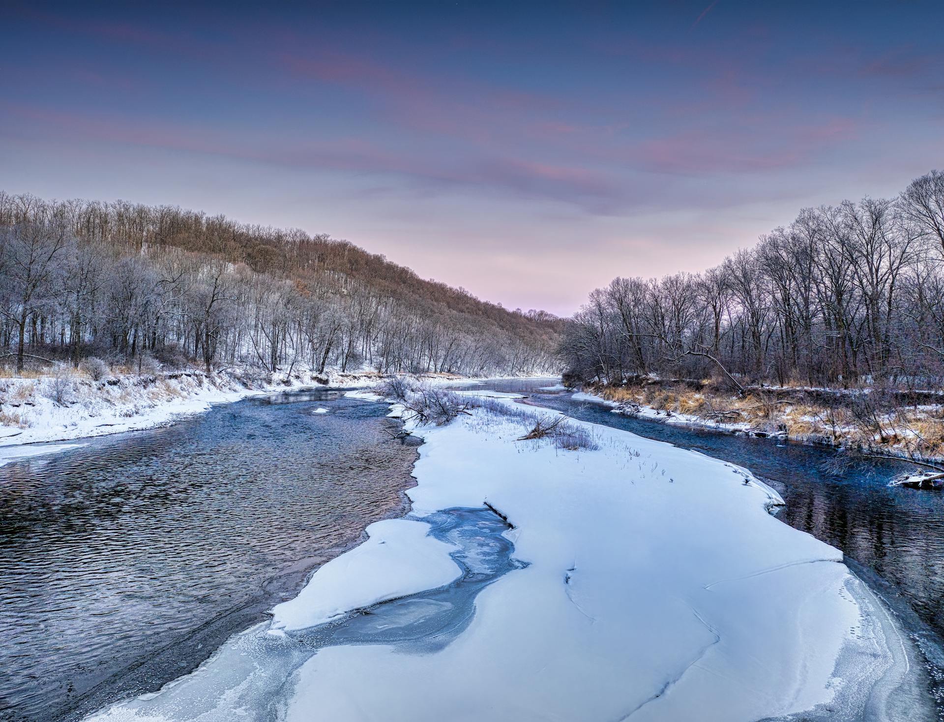 Beautiful snowy river scenery in Minnesota with frozen banks and a serene atmosphere.