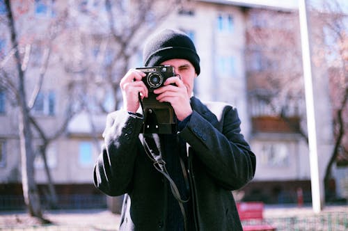 Free 
A Man in a Bonnet and a Coat Taking a Picture with a Camera Stock Photo