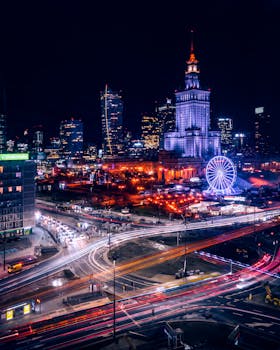 Vivid nighttime cityscape of Warsaw featuring the iconic Palace of Culture and Science and vibrant light trails.