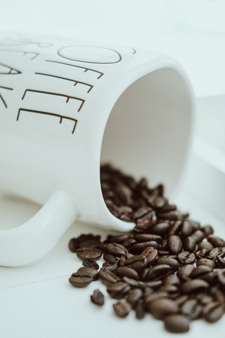 
A Close-Up Shot Of Spilled Coffee Beans From A Mug