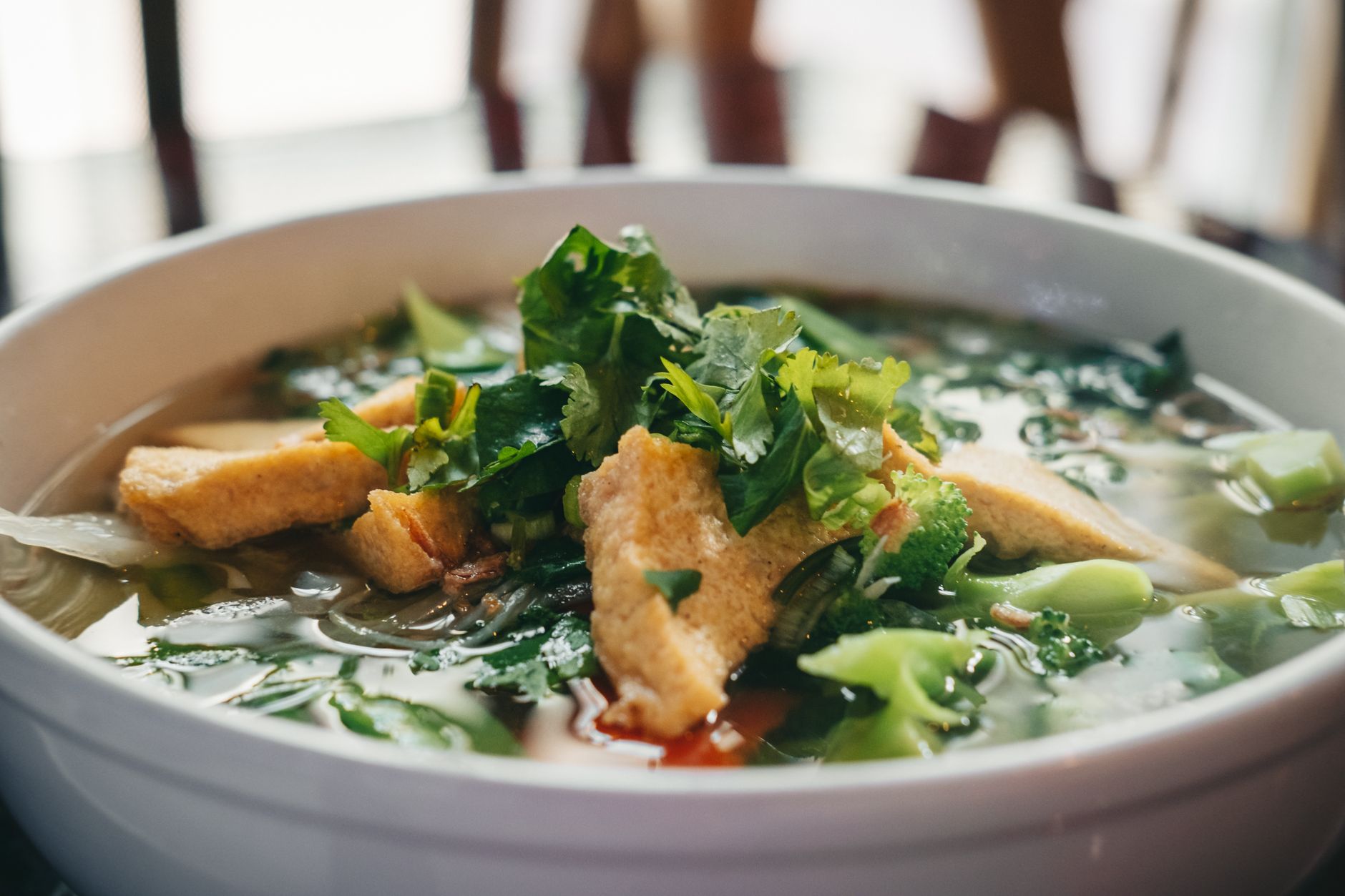 Delicious bowl of Vietnamese pho soup with tofu, herbs, and greens, perfect for food lovers.