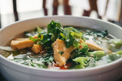 Free Delicious bowl of Vietnamese pho soup with tofu, herbs, and greens, perfect for food lovers. Stock Photo
