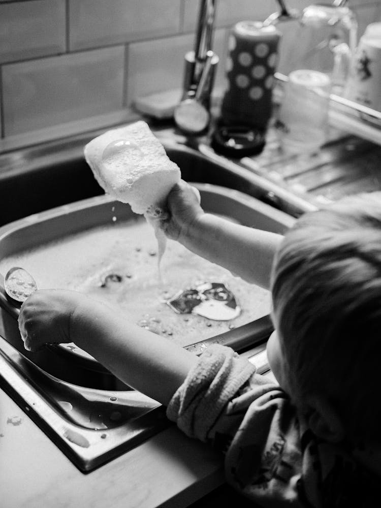 Child Holding A Soapy Sponge