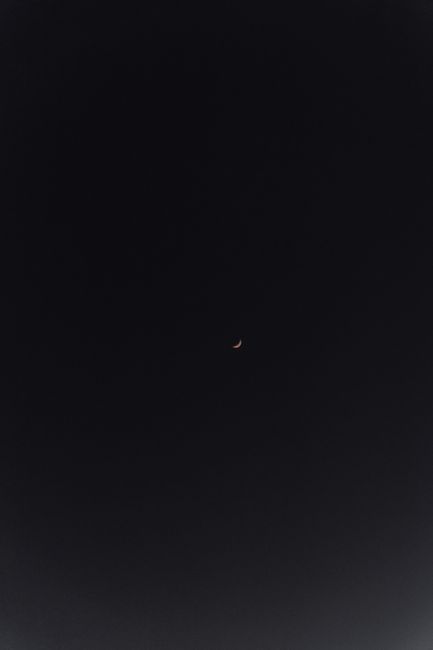 A crescent moon against a dark night sky, captured in Biarritz, France.