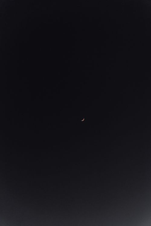 Free A crescent moon against a dark night sky, captured in Biarritz, France. Stock Photo
