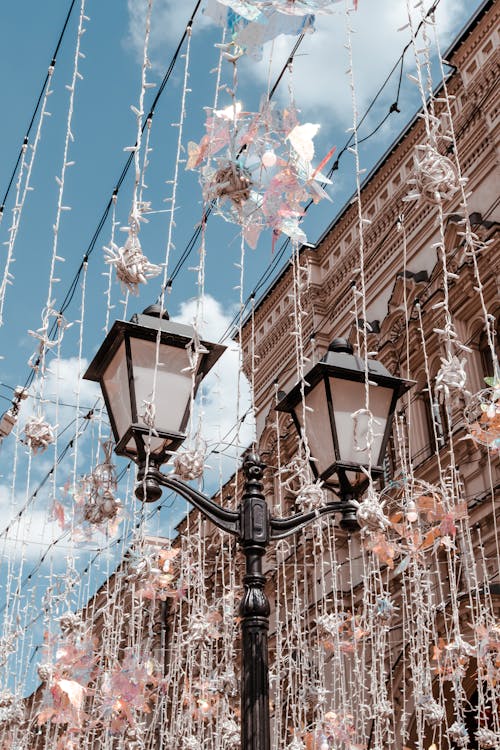 Hanging Strings of Lights Near a Lamp Posts Under a Blue Sky