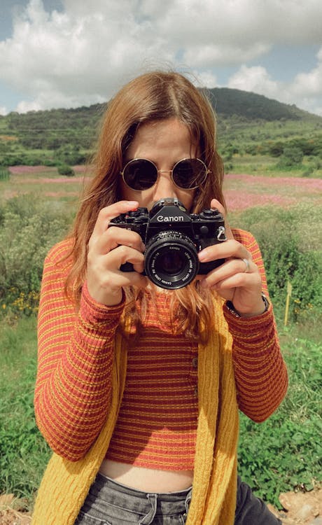 A Woman Holding a Vintage Camera 