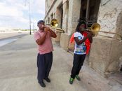 Men Playing Trumpets on Sidewalk
