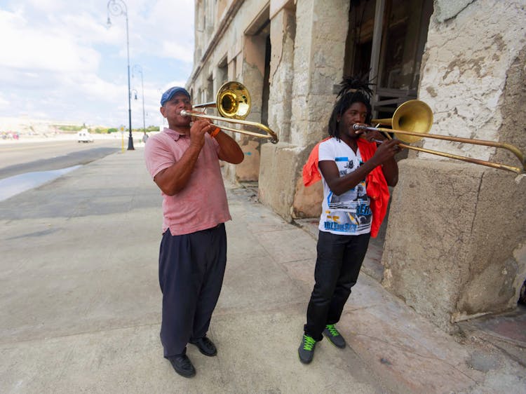 Men Playing Trumpets On Sidewalk