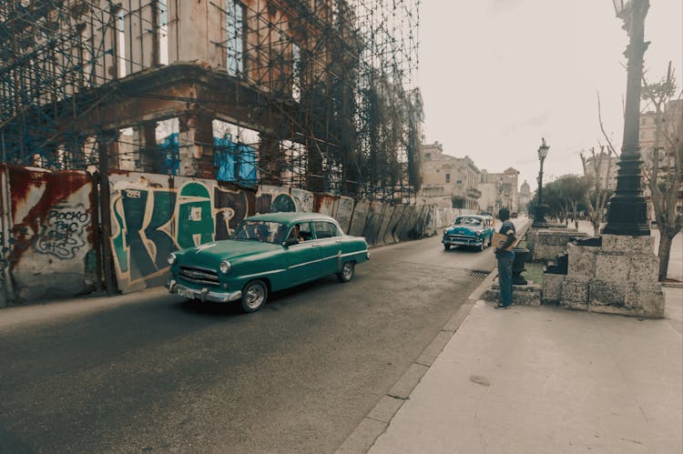 Classic Car Moving Near An Old Unfinished Building