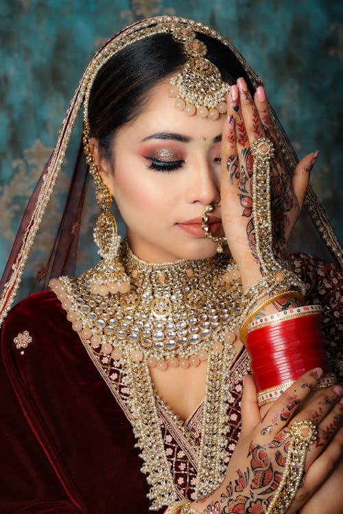Woman in Henna and Jewellery Covering Her Face with her Hand