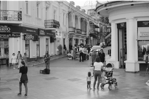 Grayscale Photography of People Walking on the Street Near Business Establishment