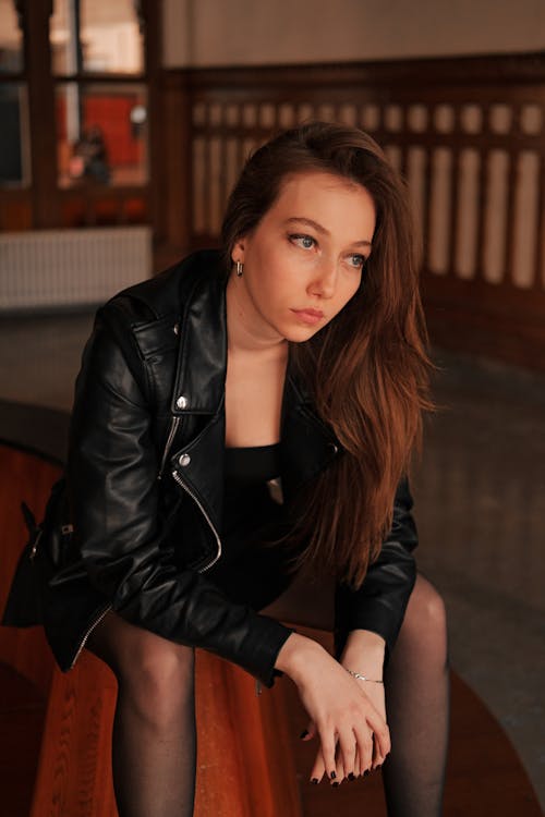
A Woman in a Leather Jacket Sitting