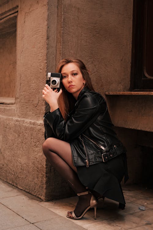 Woman in Black Leather Jacket Holding a Camera