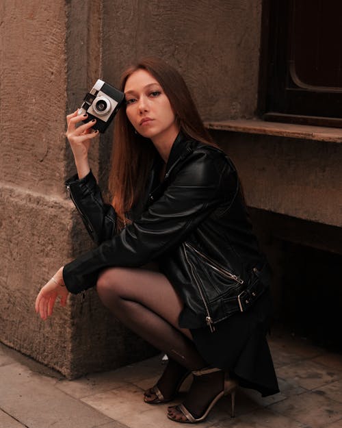 Person in Leather Jacket Holding a Camera