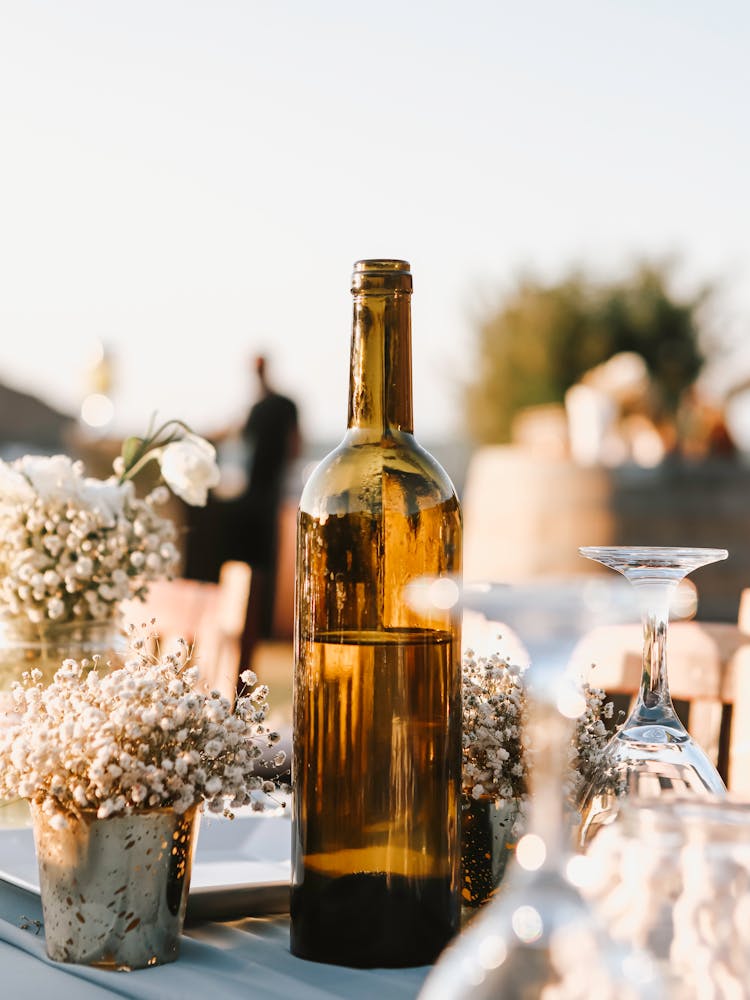 Bottle Of Wine On Table With Flowers And Glasses