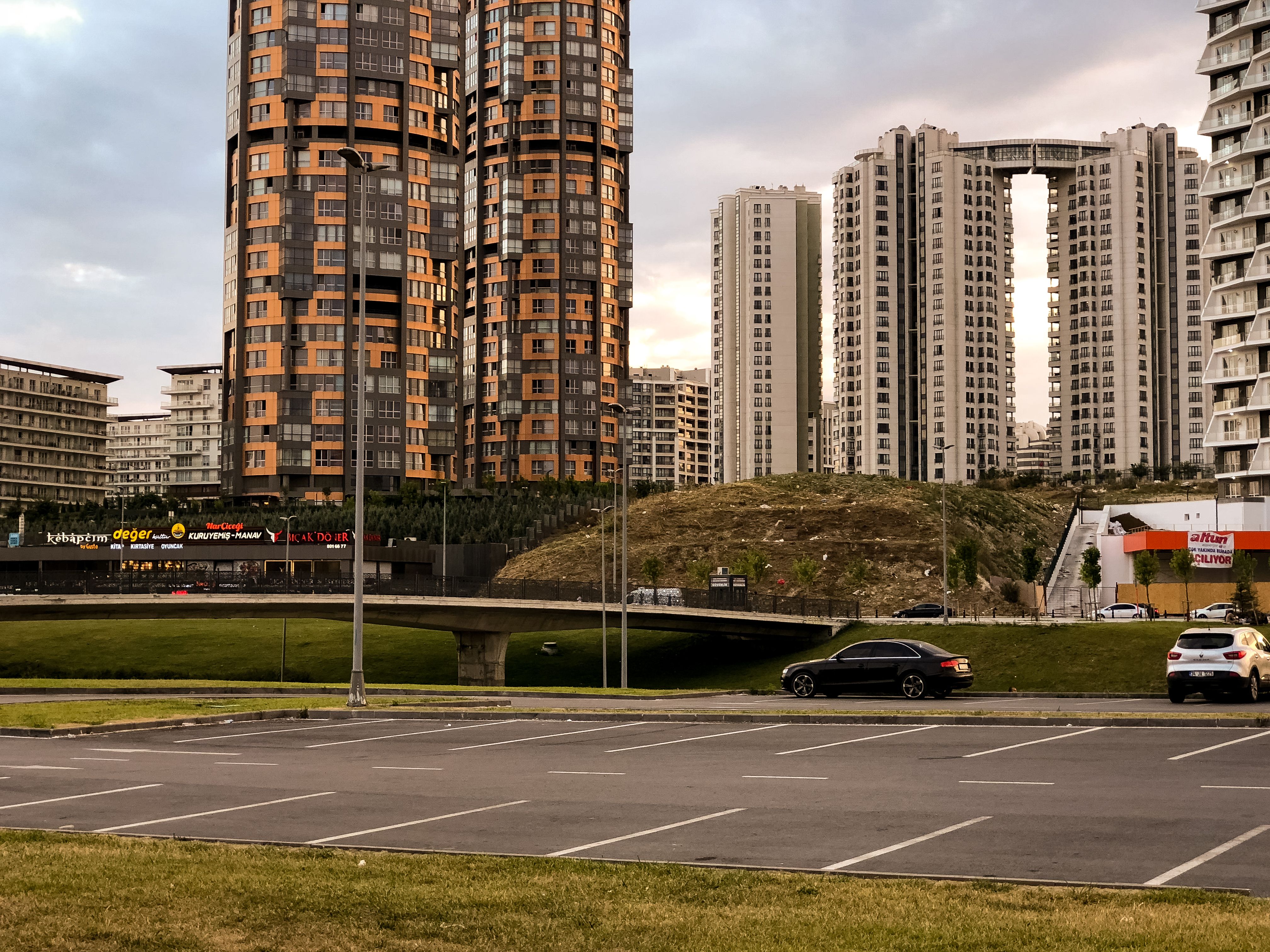 Tall skyscrapers in Istanbul's cityscape with parking and vehicles visible, showcasing modern architecture.