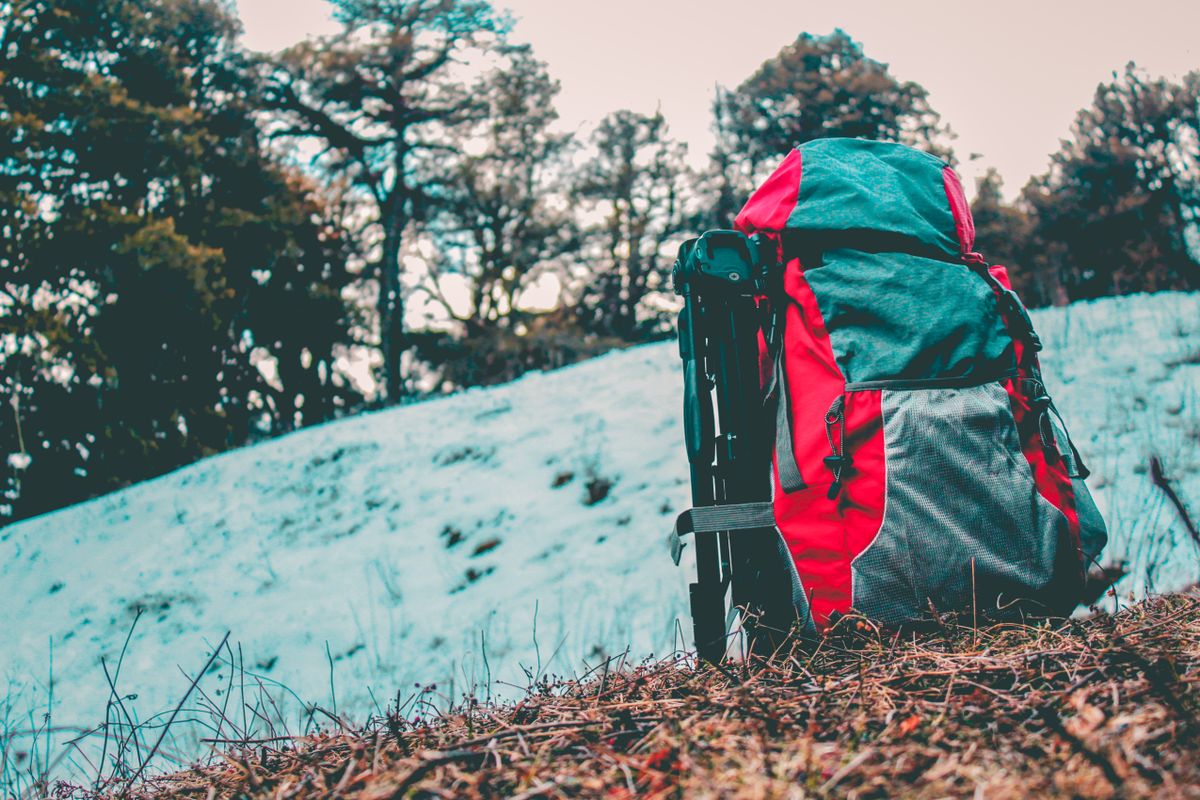 Gray and red hiking backpack with padded straps ready for a mountain trail