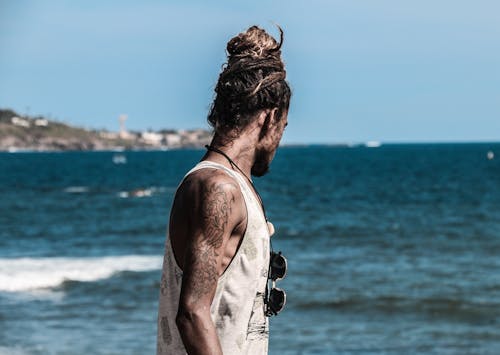 Man in White Tank Top on Seashore