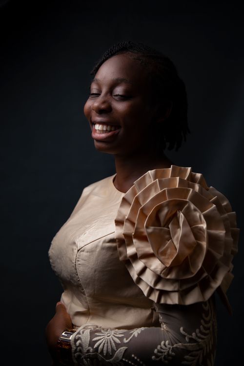 Free Portrait of a cheerful woman in a unique, elegant dress with a dramatic floral design. Stock Photo