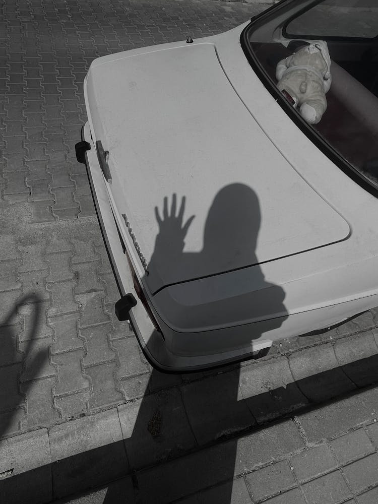 Shadow Of Person Waving On Car Hood