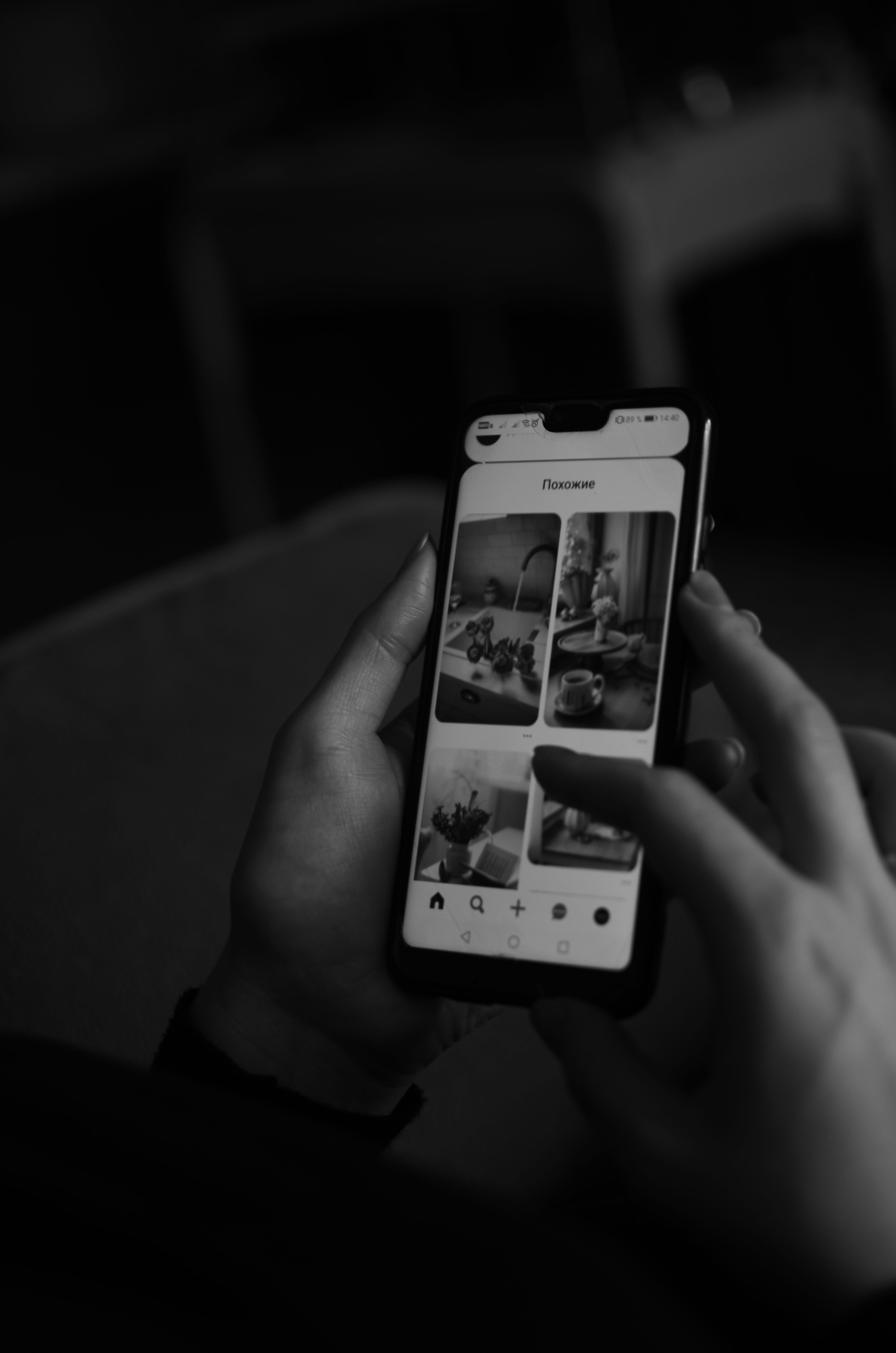 A hand scrolling through a social media app on a phone
