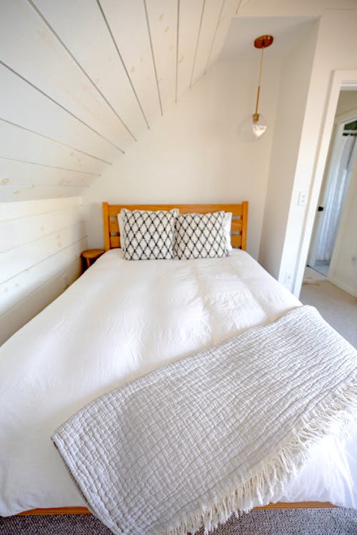 Photograph of a Bed with a White Sheet and Pillows
