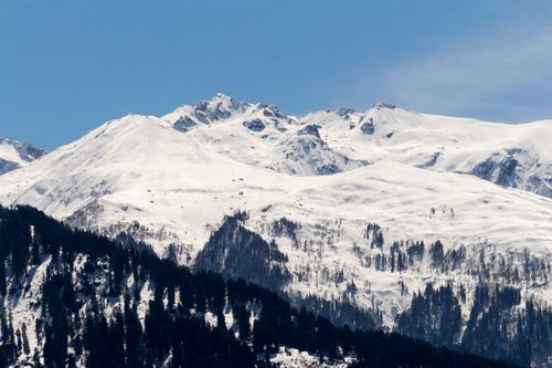Free Stunning view of a snow-covered mountain range under a clear blue sky, showcasing winter beauty. Stock Photo