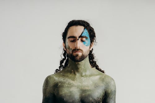Man with his Eyes Closed and Body Painted with Hues of Green 