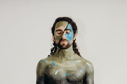 Man with his Eyes Closed and Body Painted with Hues of Green 
